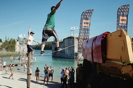Slackline event with crowd at a lake (desktop)