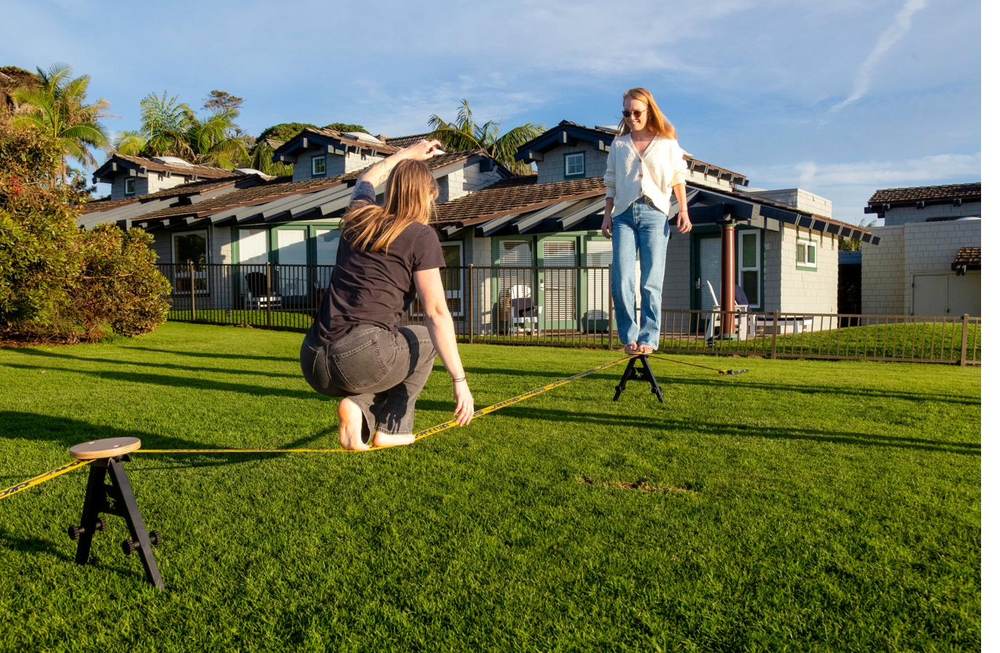 Woman balancing on the SlackYard with a spotter