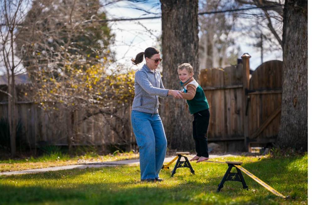 Parent helping a child balance on the SlackYard