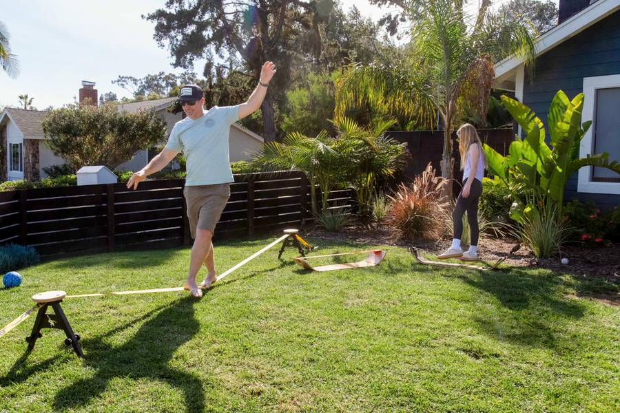 Man walking a SlackYard while a child watches